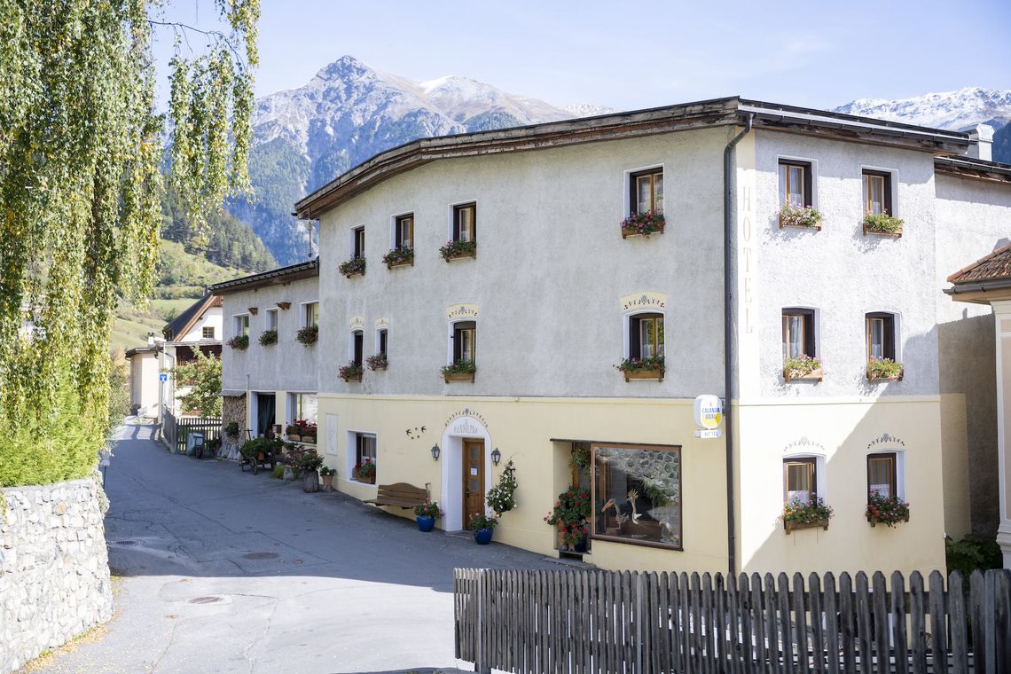 Das Haus von La Randulina in Ramosch, mit den Bergen dahinter.