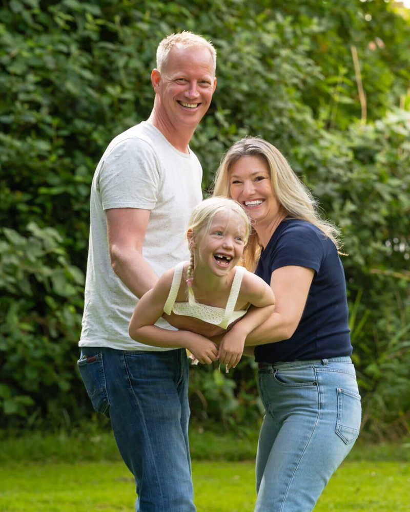 John, Ilona und Luna, lachend im Garten.
