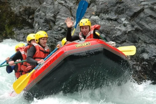 Een raft met helmen en peddels door het witte water van de Inn.
