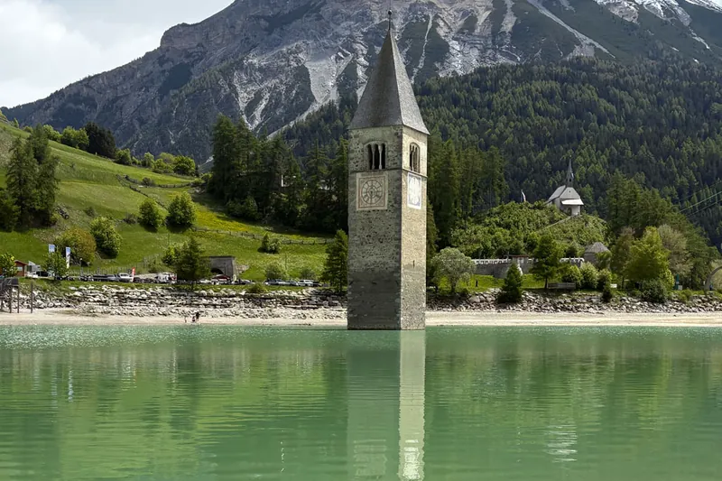 De kerktoren die uit het water van de Reschensee oprijst.