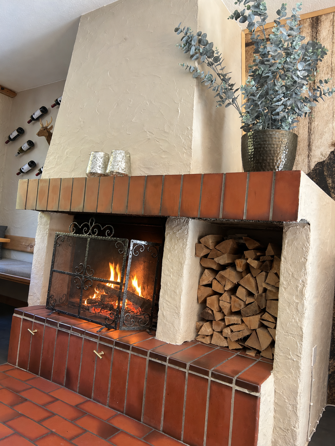 Ein brennendes Holzfeuer hinter dem Kaminschirm in der Stube von La Randulina.