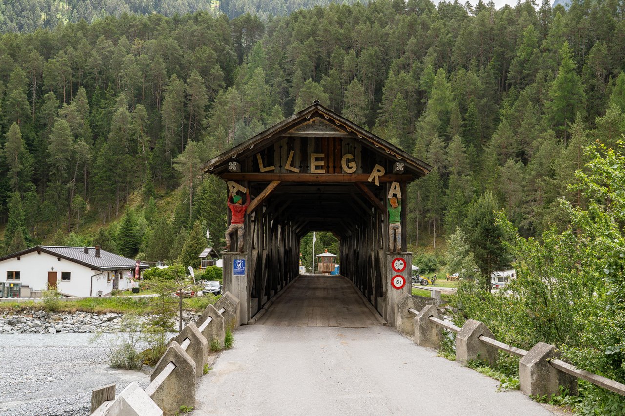 The covered wooden bridge over the Inn at Sur En, with woodland behind.